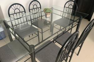 a glass table with chairs and a plant on it at Suite de lujo Punta Centinela in La Libertad