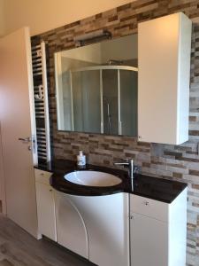 La salle de bains est pourvue d'un lavabo et d'un miroir. dans l'établissement Podere Baratta agriturismo e cantina, à Collinello