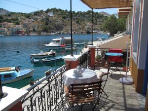 a balcony of a house with boats in the water at Nikolitsi Studios in Symi