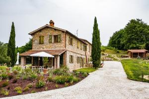 - Vistas al exterior de una casa de piedra con jardín en Tenuta Gambit Agriturismo Umbria, en Monteleone dʼOrvieto