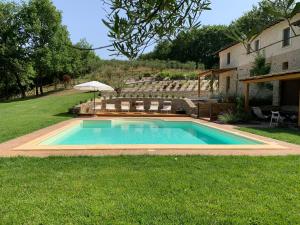 een zwembad in een tuin met stoelen en een parasol bij Tenuta Gambit Agriturismo Umbria in Monteleone dʼOrvieto