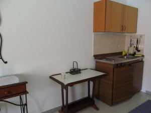 a small kitchen with a sink and a table at Nikolitsi Studios in Symi