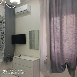 カステッランマーレ・ディ・スタービアにあるL'acchiappasogni casa vacanzeのピンクのカーテンとドレッサーのある部屋