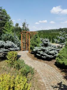 a path in a garden with a wooden arch at Domek na wsi nad jeziorem , prywatny staw in Kamieńczyk Dezerta +5 photos
