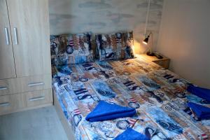 a bed with blue pillows on it in a bedroom at къщички Поляните in Sinemorets