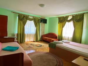 a room with two beds and a couch in it at Casa Mary in Haţeg