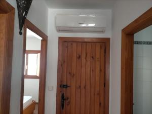 a bathroom with a wooden door and a window at Casa Paulonia in Las Negras