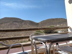 a table and chairs on a balcony with mountains in the background at Casa Paulonia in Las Negras