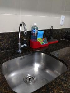 a sink with a bottle of water sitting next to it at Praia dos Carneiros Flat Hotel Lindo Apto 302 in Praia dos Carneiros