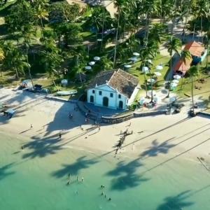 an aerial view of a beach with a building in the water at Praia dos Carneiros Flat Hotel Fantástico in Tamandaré