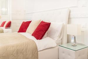 1 dormitorio con cama blanca y almohadas rojas en Music Academy Suite Café Vian Apartman Kft, en Budapest