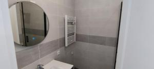 ein Badezimmer mit einem Spiegel und einem Waschbecken in der Unterkunft Soleil Roi - immeuble du 16e siècle en plein coeur de Béziers in Béziers