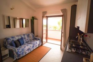 a living room with a couch and a kitchen at Sea View Vista Mare - Soggiorni settimanali da sabato a sabato in Isola Capo Rizzuto
