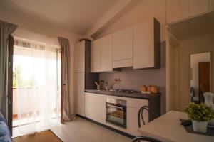 a kitchen with white cabinets and a stove top oven at Sea View Vista Mare - Soggiorni settimanali da sabato a sabato in Isola Capo Rizzuto