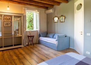 una camera da letto con un divano blu e una finestra di CasaBiondani Lazise a Lazise