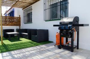 - un barbecue dans une terrasse avec une table et un banc dans l'établissement Zapata Home, à Alhaurín de la Torre