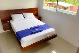 Un dormitorio con una cama con una toalla azul. en Puerto Viejo Lodge, en Puerto Viejo
