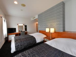 大垣市にあるアパホテル 大垣駅前のベッド2台とテレビが備わるホテルルームです。