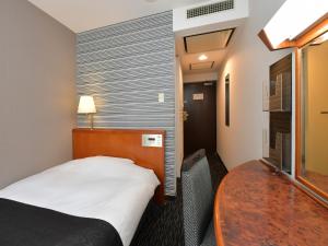 a hotel room with a bed and a table at APA Hotel Ogaki Ekimae in Ogaki