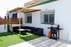 une terrasse avec un grill, une table et un grill dans l'établissement Zapata Home, à Alhaurín de la Torre