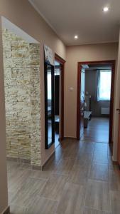 a room with a stone wall and a hallway at Korzó Apartman Velence in Velence