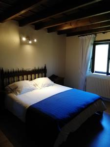 una camera da letto con un grande letto con una coperta blu di La Casa Nueva Alojamiento Rural a Cereceda