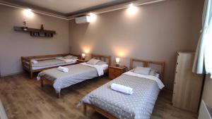 a room with two beds and two chairs in it at Korzó Apartman Velence in Velence
