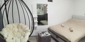 a bedroom with a bed and a chair and a mirror at APARTMENTS IVANOViC in Bajina Bašta
