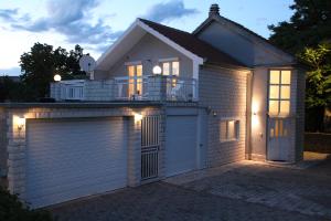 une maison blanche avec garage la nuit dans l'établissement Kroatien Villa Merćepi, à Katuni