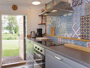 eine Küche mit einem Herd und einer Wand aus Fliesen in der Unterkunft 4 person holiday home in N SSJ in Nässjö