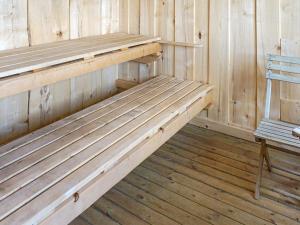 un banco de madera en una sauna con una silla en 4 person holiday home in N SSJ, en Nässjö