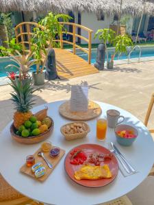 a table with a breakfast of fruit and juice at TAKUMA BOUTIK HOTEL in Las Terrenas