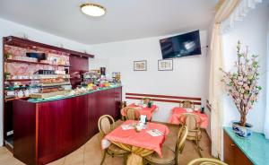 a restaurant with two tables in front of a counter at Hotel Boccascena in Genoa
