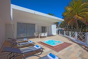 a patio with chairs and a hot tub on a deck at PLAYA CHICA by Buenavilla in Puerto del Carmen