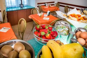 a table with a bowl of strawberries and fruit on it at Hotel Boccascena in Genoa