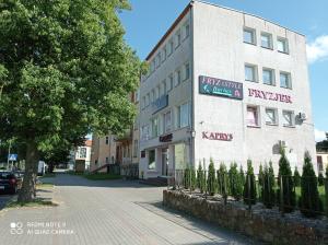 un edificio blanco con un cartel en el costado en Apartament Wanessa, en Kętrzyn
