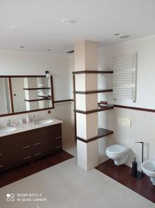 a bathroom with a sink and a toilet and a mirror at Apartament Wanessa in Kętrzyn