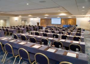 a conference room with tables and chairs and a screen at Mediterranean Beach Hotel in Limassol +37 photos