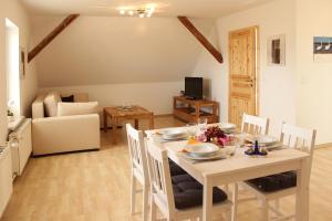 a dining room with a white table and chairs at Ferienhaus Segebrecht in Zirchow