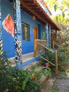 a house with a blue facade and a porch at Entre Montanhas Capão in Vale do Capao