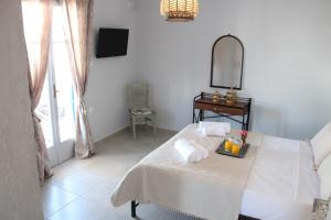 a white room with a bed and a mirror at Harmony Villa Milos in Pollonia