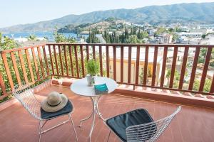 einen Tisch und Stühle auf einem Balkon mit Aussicht in der Unterkunft Sophie's Apartment 1&2 in Poros