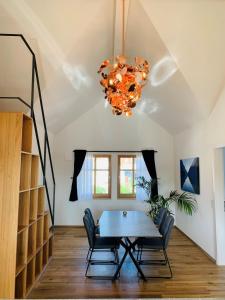 a dining room with a table and chairs and a chandelier at Loft über dem Bodensee in Heiligenberg