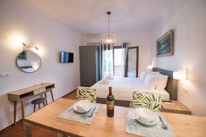Zimmer mit einem Bett und einem Tisch mit einer Flasche Wein in der Unterkunft Sophie's Apartment 1&2 in Poros