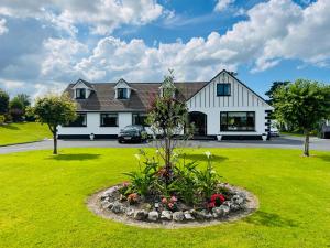 戈特Cedar Lodge Self Catering Accommodation H91 CF9D的一栋前面带花园的房子