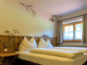 Un dormitorio con una cama con almohadas blancas y una ventana en Alpengasthof Hochsöll, en Söll