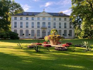 a large white building with a flower garden in front of it at Ferienwohnung Prüfer in Greiz