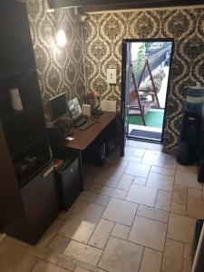 un bureau avec un bureau et un ordinateur sur du carrelage dans l'établissement Mpoint Motel, à Bucarest