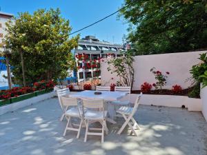 een tafel en stoelen op een patio met bloemen bij Easo Terrace Apartment free private parking and air conditioning in San Sebastian