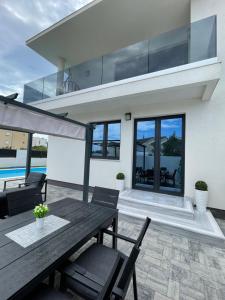 a house with a wooden table and chairs on a patio at Villa Eureka in Vodice